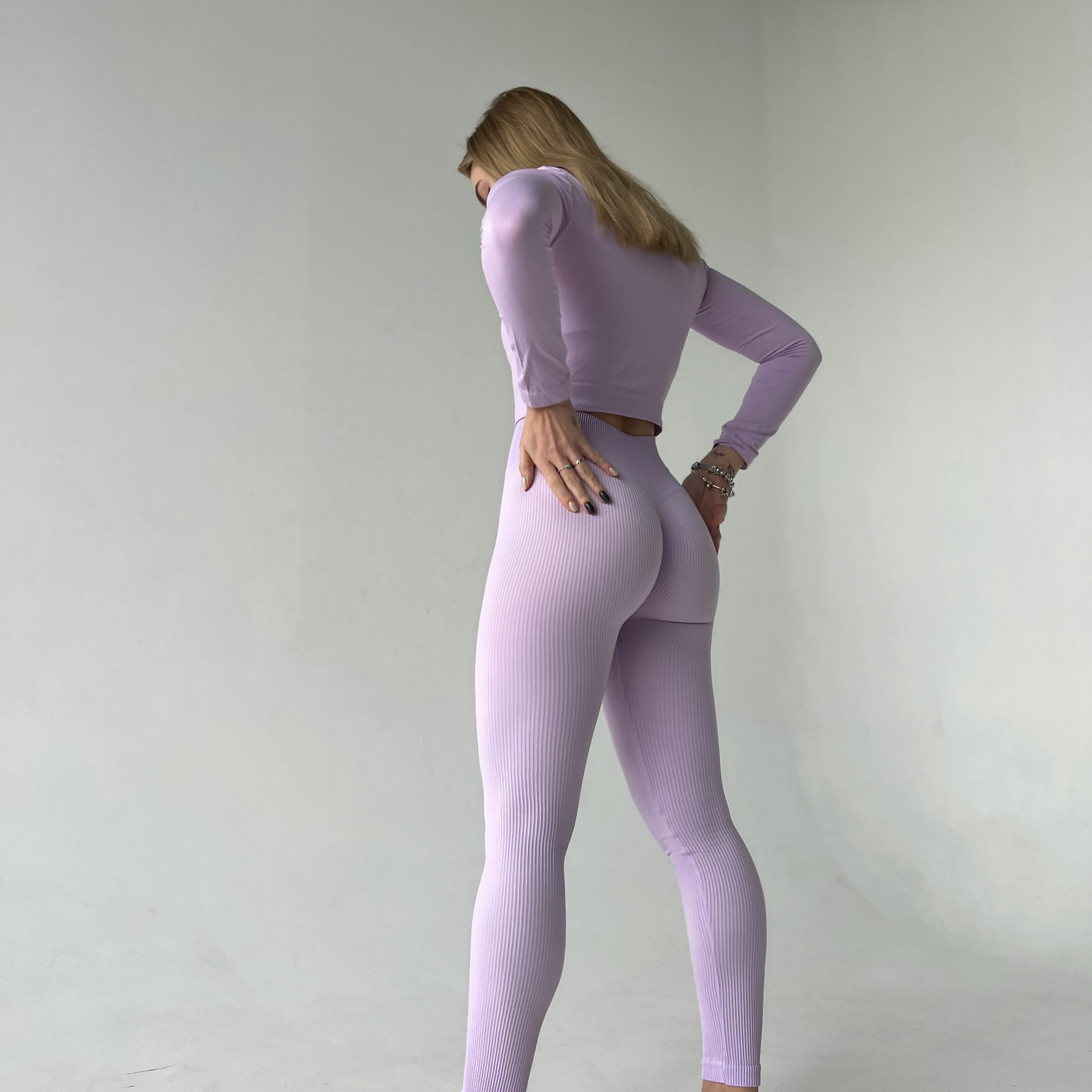 girl standing wearing a purple matching gym set 